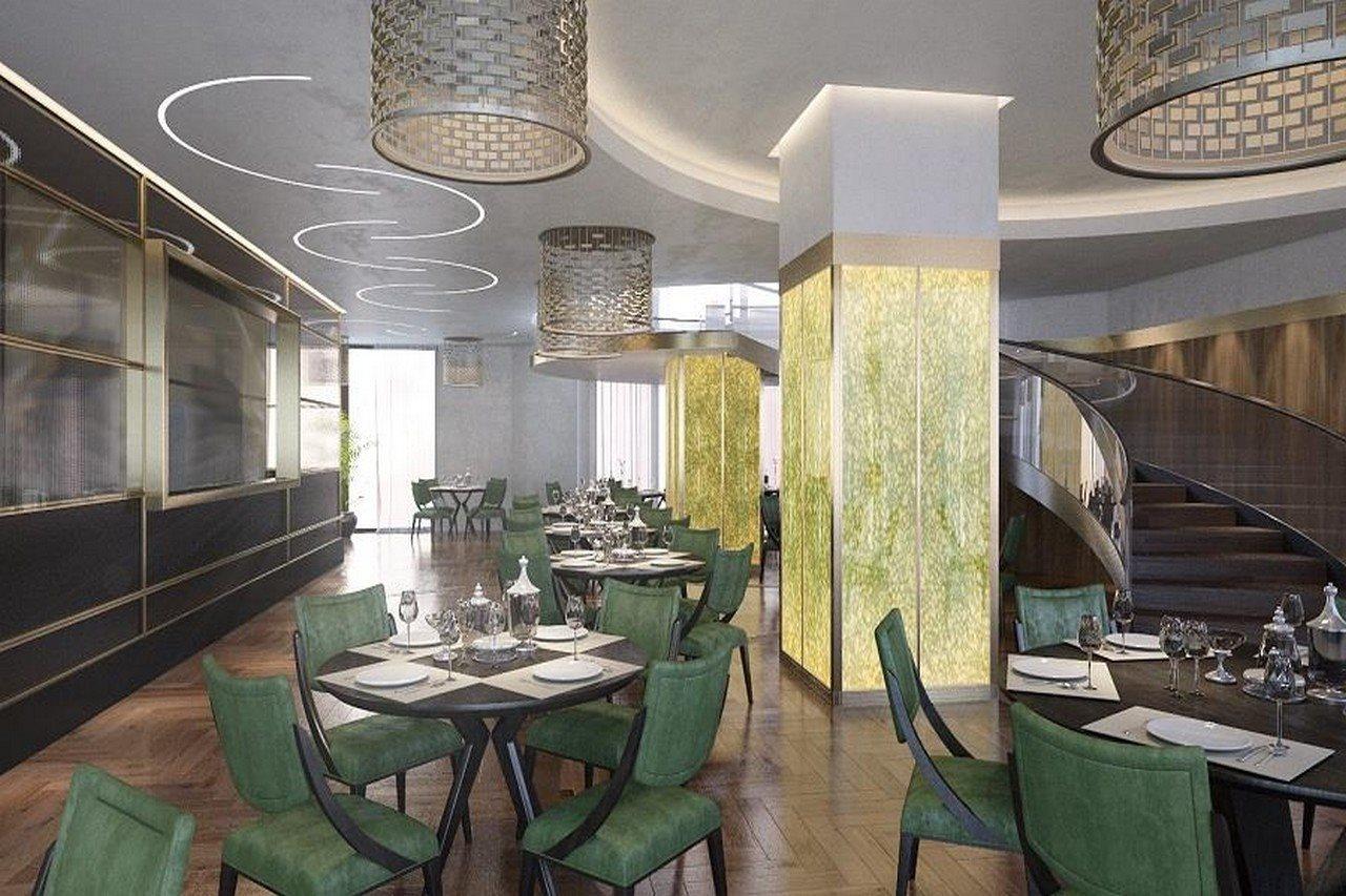 Grand Swiss-Belhotel Waterfront Seef Sanabis Exterior photo The photo shows an elegantly designed restaurant interior. It features a mix of modern and sophisticated elements, with stylish green chairs around neatly set tables that include white tablecloths, plates, and cutlery. The lighting is provided by uni